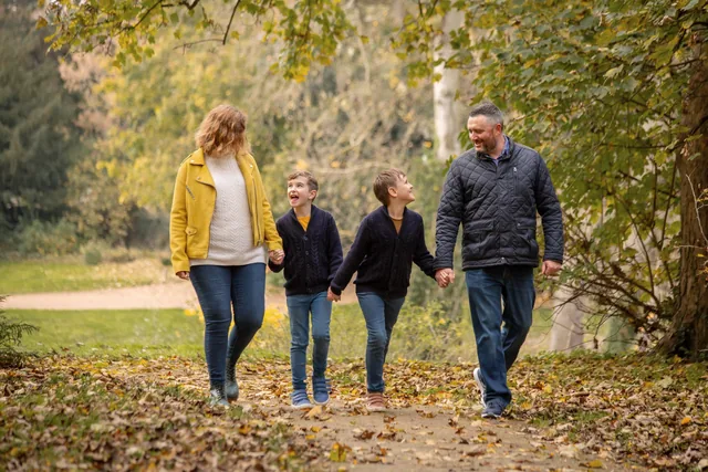 Claire and her family holding hands during an autumn walk