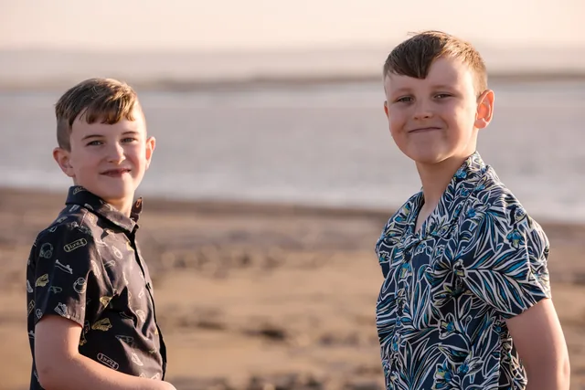 A close portrait of Claire’s two boys together at the beach