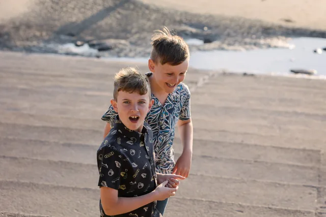 Claire’s boys laughing and playing together on the sand