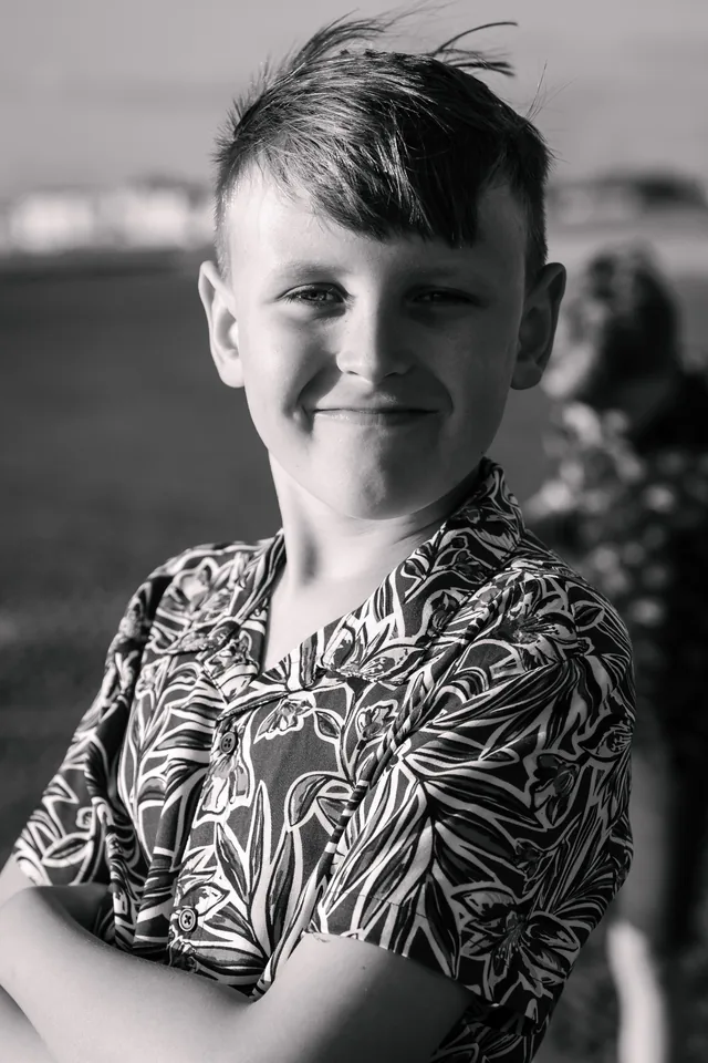 Black and white beach portrait of one of Claire’s boys smiling