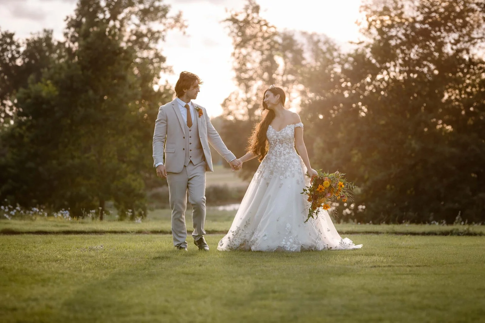A wedding couple walking together in warm evening light